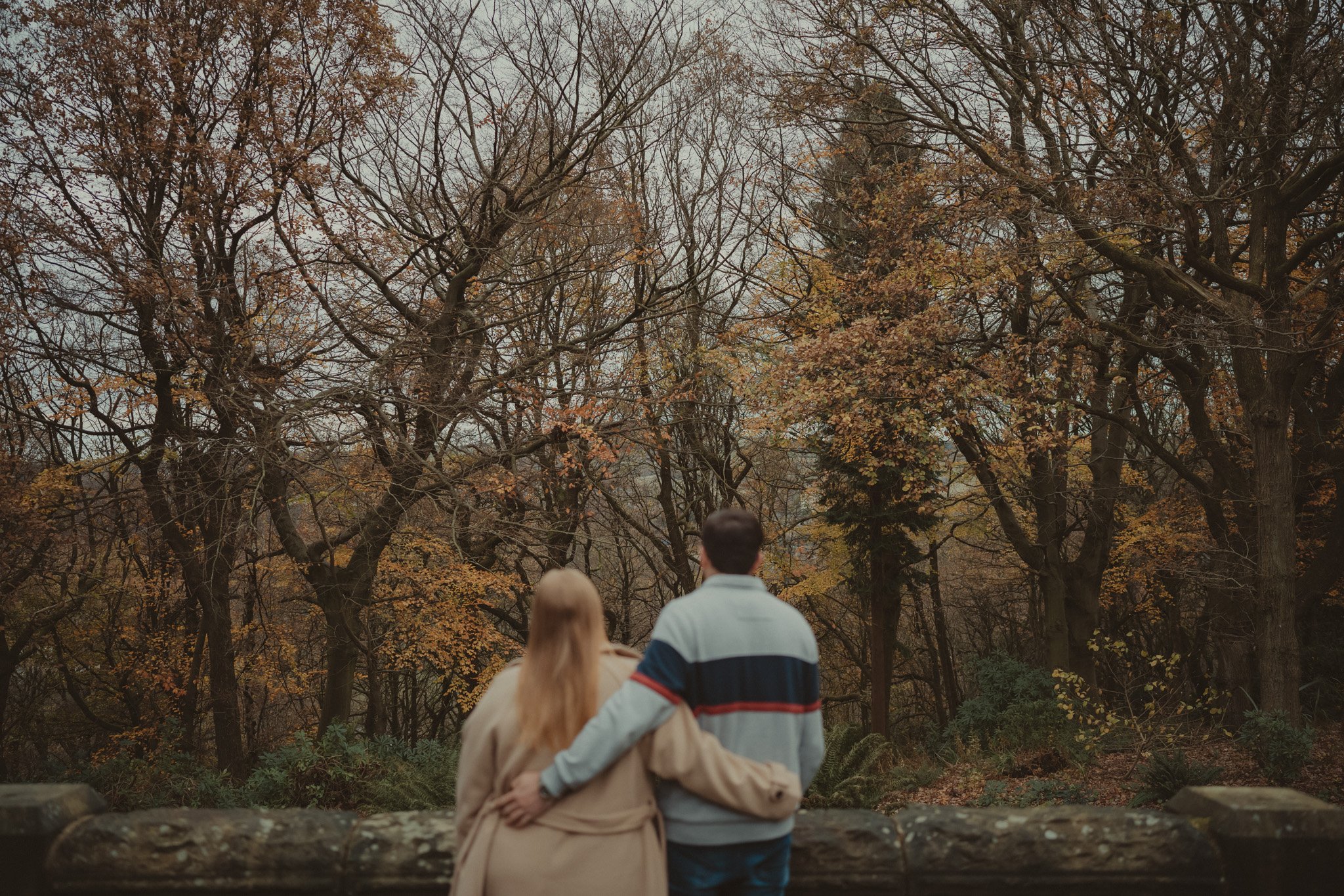 Couple holding each other with their backs at the camera during a autumn save the date photoshoot in Huddersfield