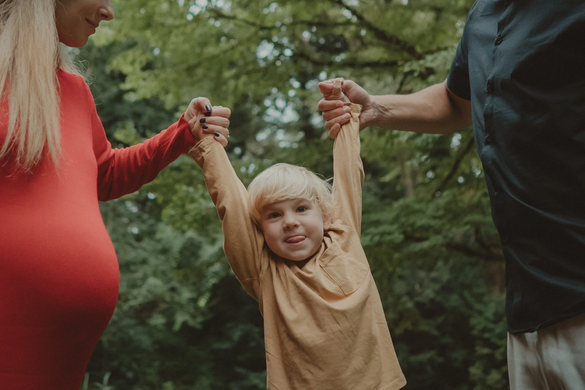Boy holding his parent's hands 