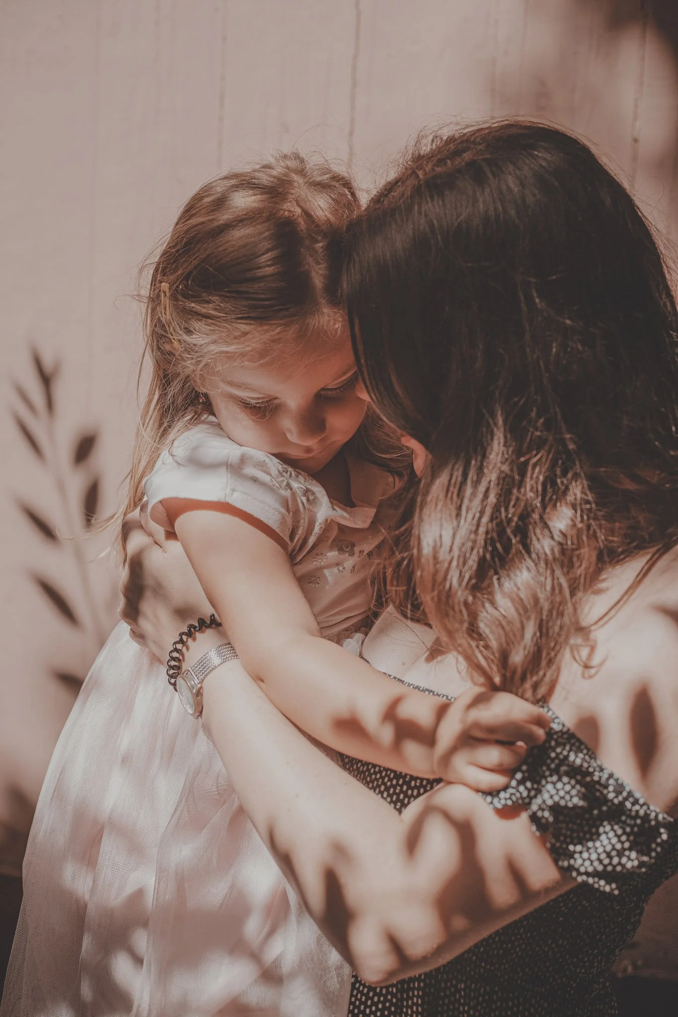 Mother and her little daughter sharing a genuine moment together during a family photoshoot