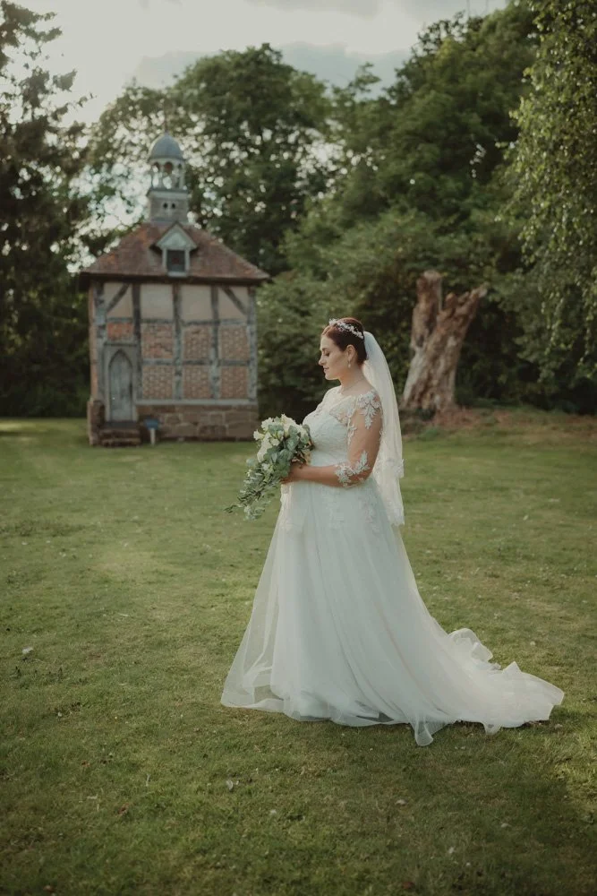 Full body portrait of a bride on the grounds of Brockencote Hall Hotel, Kidderminster