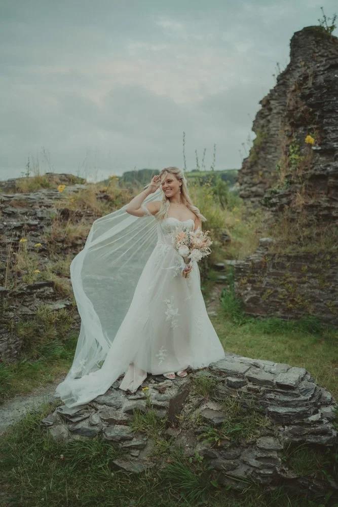 Beautiful vertical photo of a young bride playing with the veil in the wind, in Wales