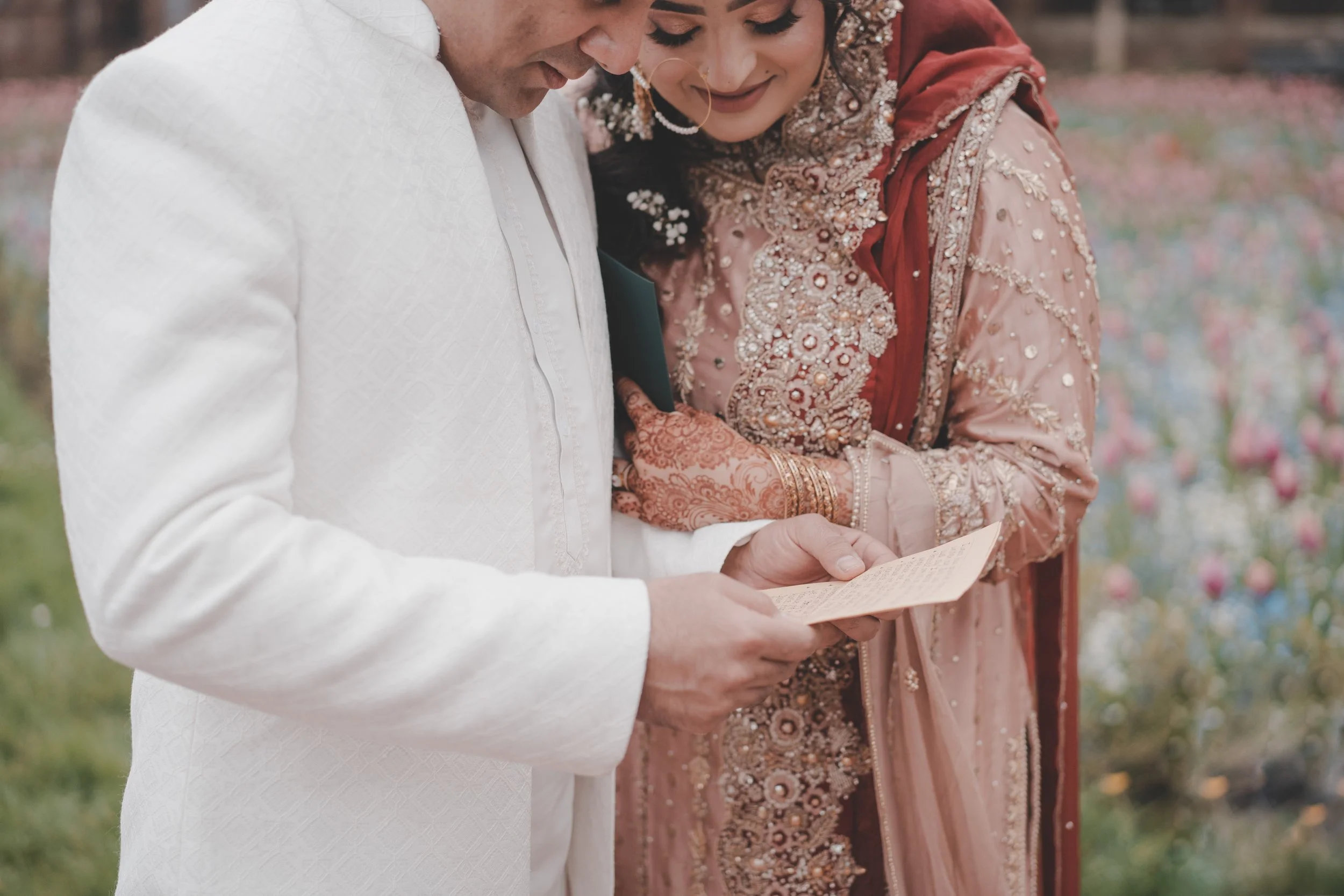 Bride and groom in islamic traditional clothes reading a letter on their wedding day
