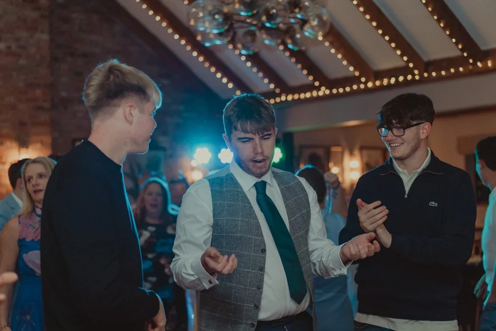 Young men photographed dancing at a wedding at The Waterfront Barton Marina
