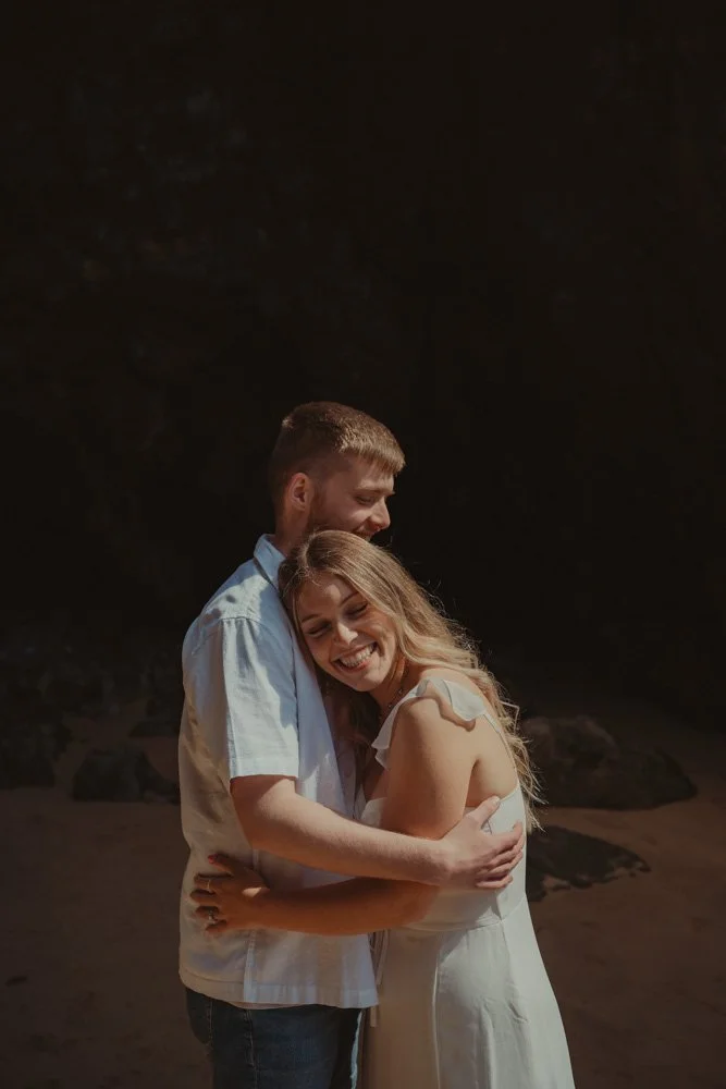 Girl laying her head on her boyfriend's shoulder for a portrait, at a pre-wedding photo session, in Wales, UK
