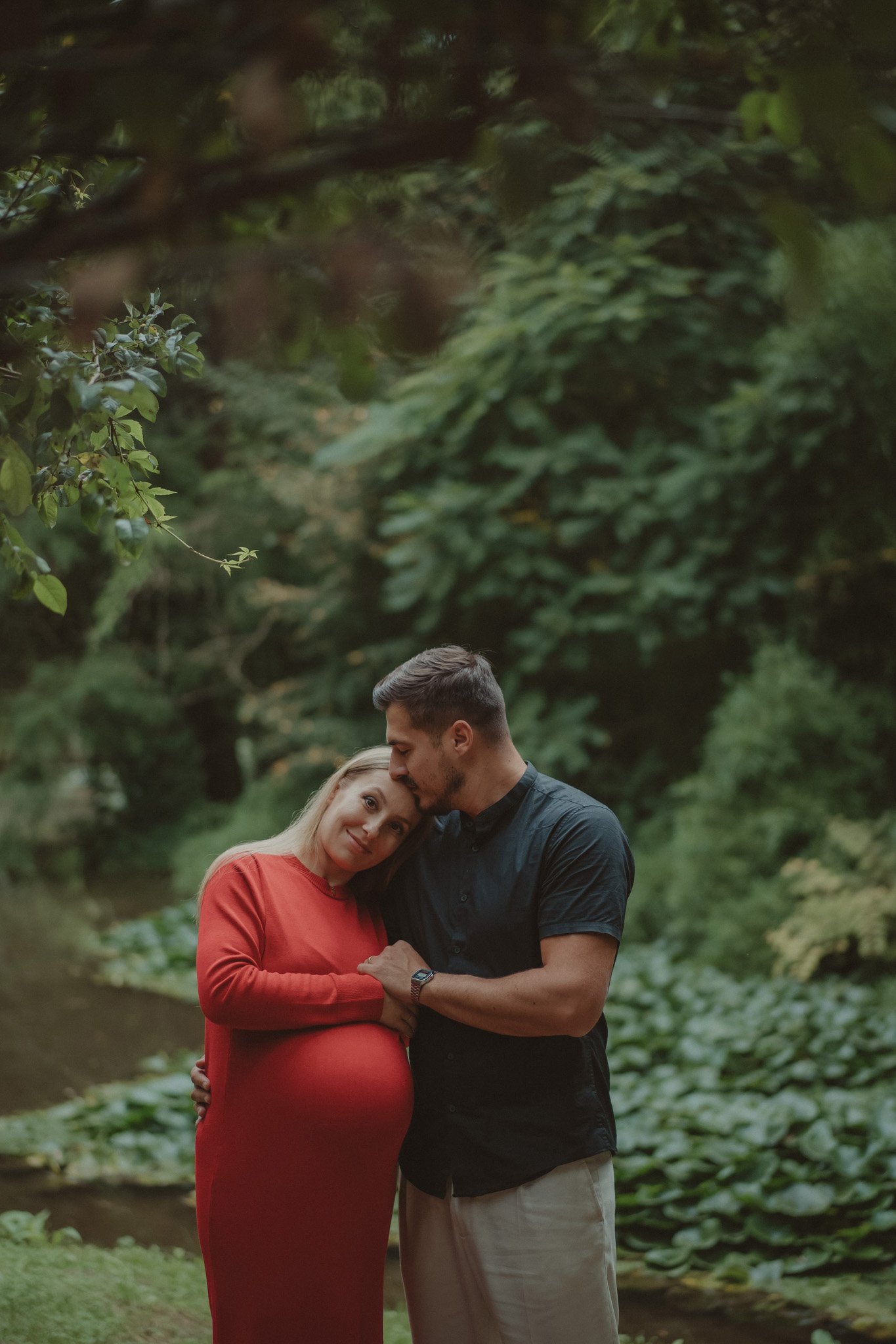 Husband kissing his wife's forehead during a family and maternity photoshoot