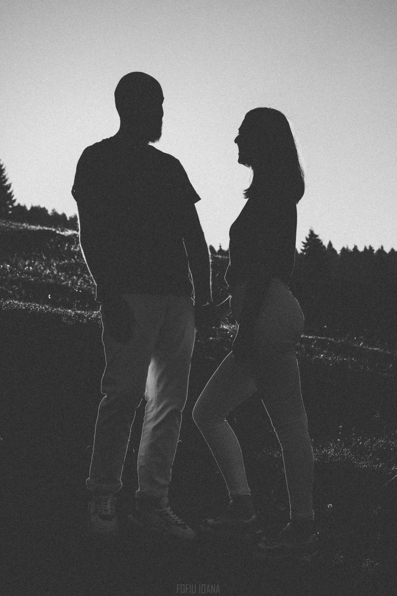 Contre jour black and white photo of couple during sunset, on a hill