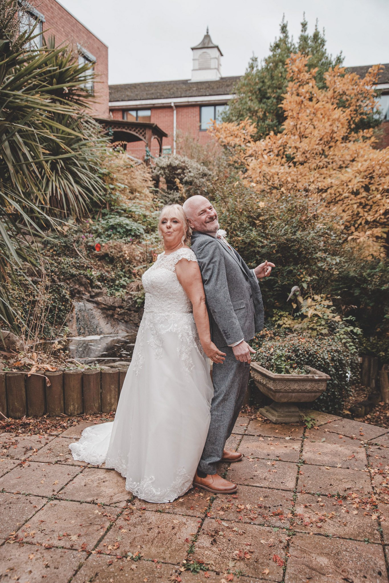 Older bride and groom having fun during their wedding day photoshoot, in Coventry at Arden Hotel