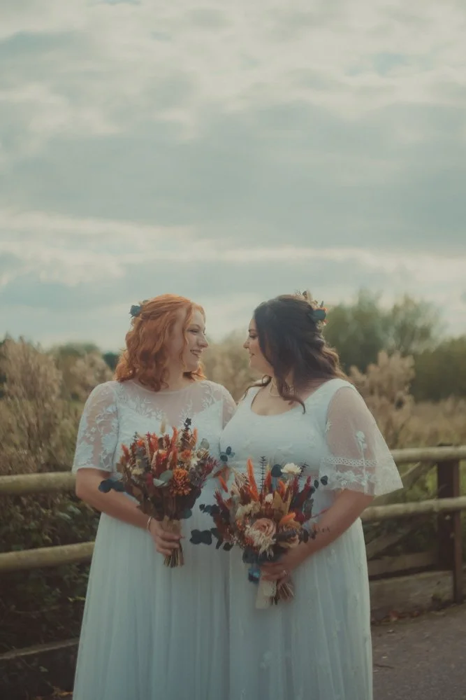 Portrait of two brides looking at each other at their LGBTQ wedding, at The Chester Fields Country Pub, Restaurant & Wedding Venue, UK