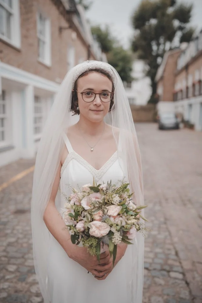 Portrait of a bride holding her flowers on the streets of London