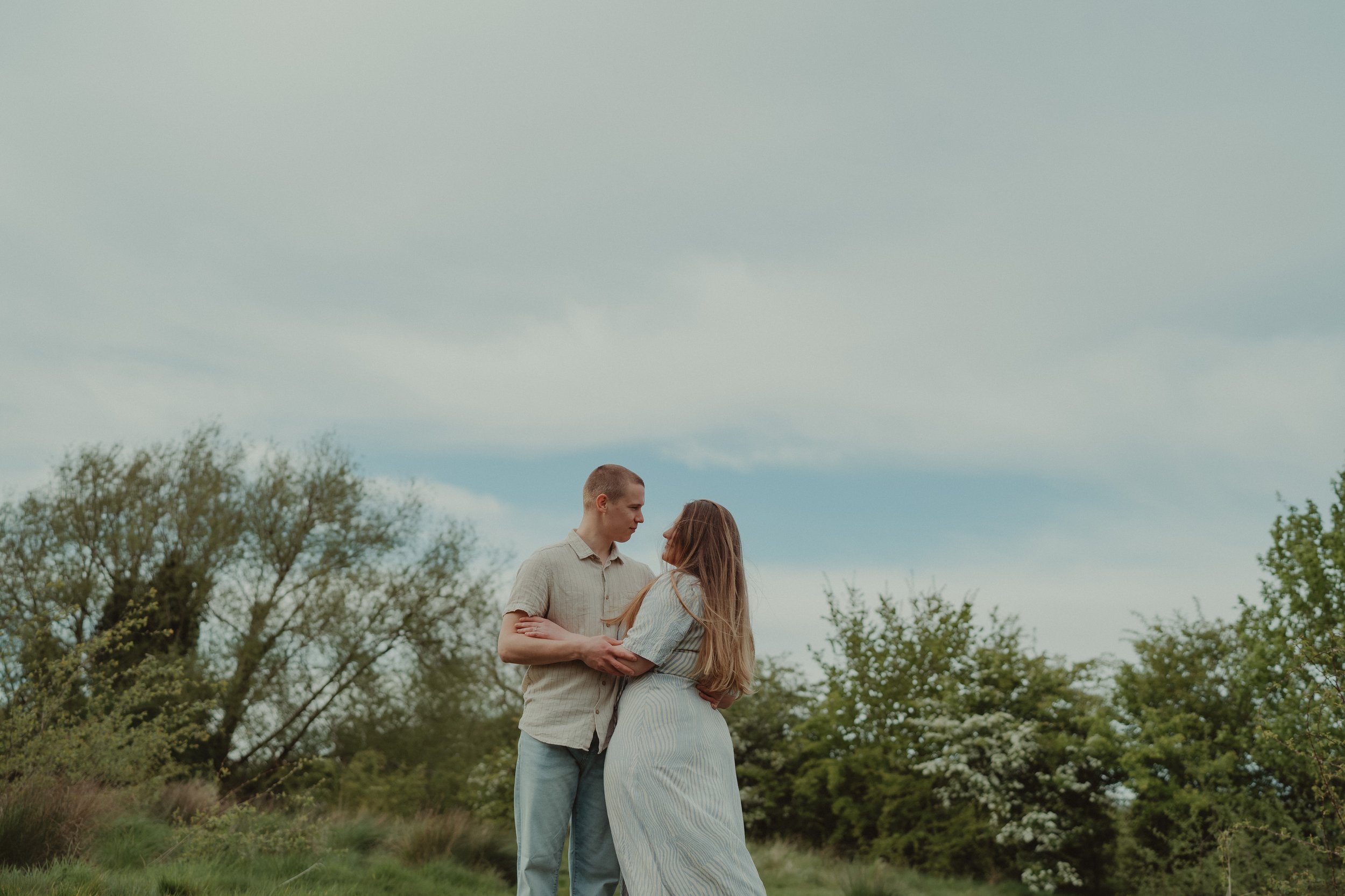 Young couple photographed from afar, on a field in Hoveringham