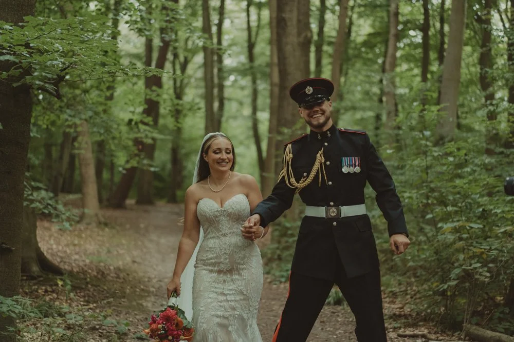 Groom in military outfit and bride photographed having fun in the forest of Basingstoke, UK