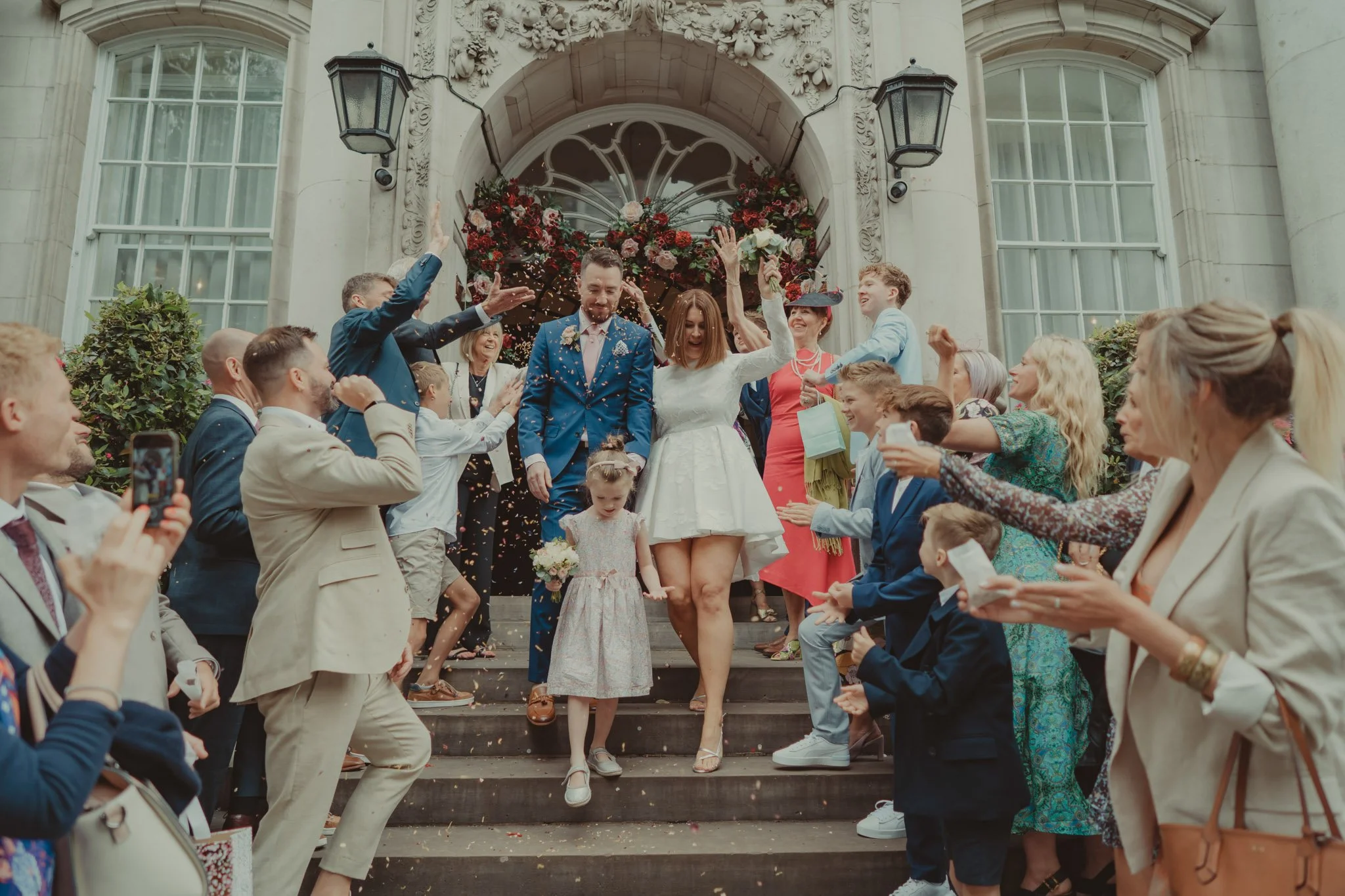 Confetti shot with bride, groom and guests on the stairs of Chelsea Old Town Hall, London 
