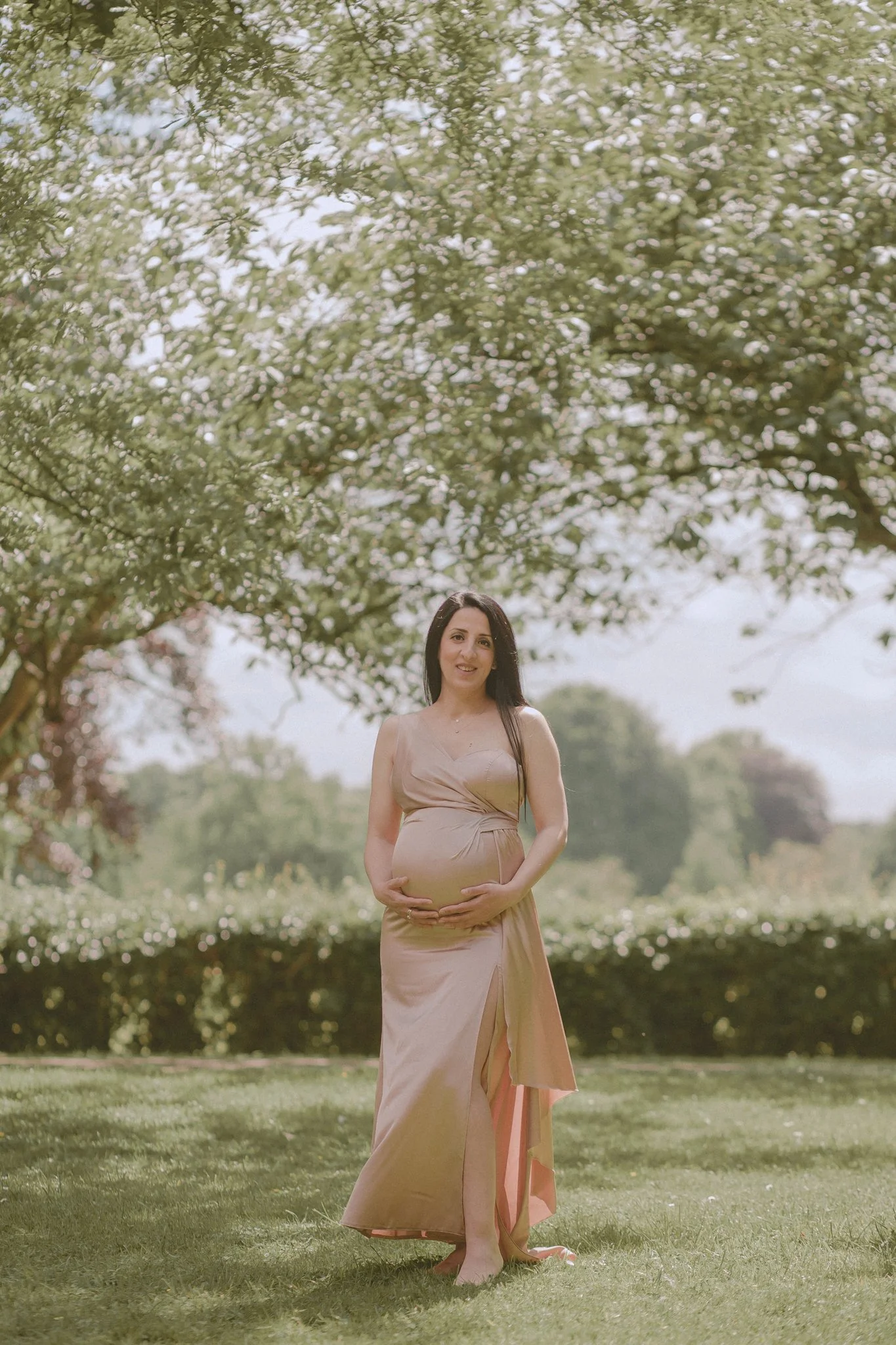 Pregnant woman holding her belly during a maternity photoshoot in Coventry