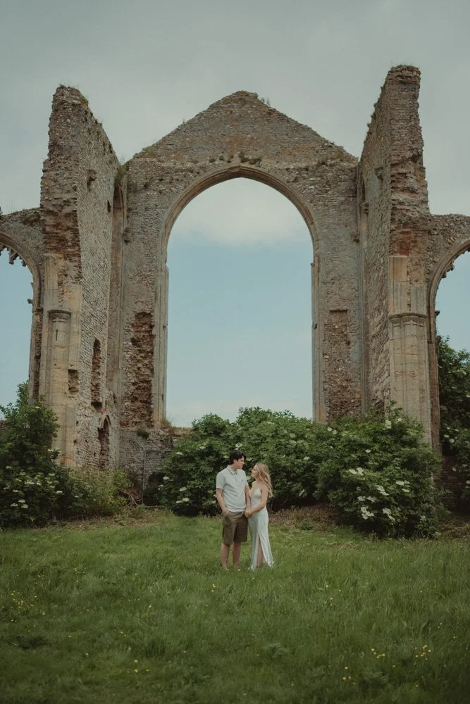 Young couple photographed from afar, at some ruins near Covehithe Beach