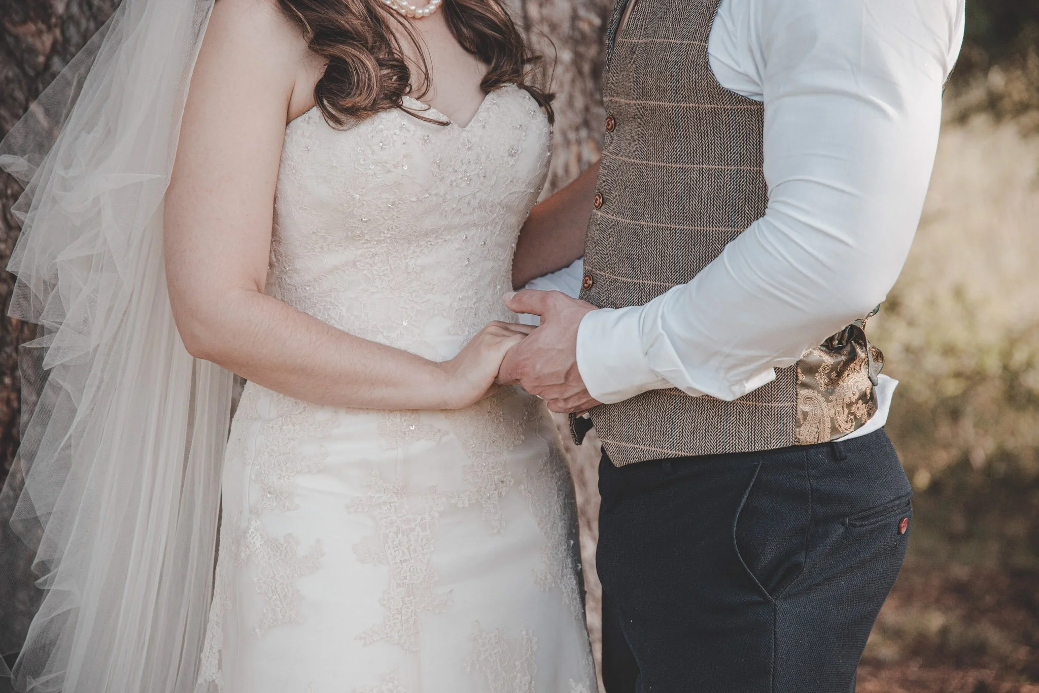 Details of bride and groom holding hands on their wedding day photoshoot