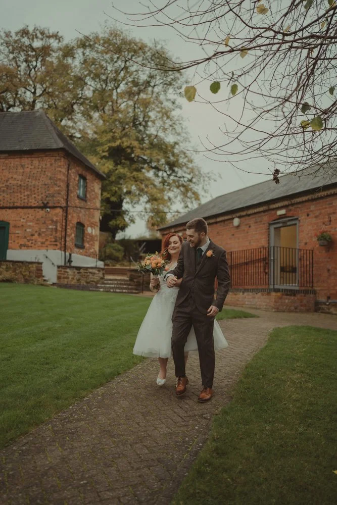 Newlywed couple playing during a couple photoshoot on their wedding day, at The Barns at Hunsbury Hill 
