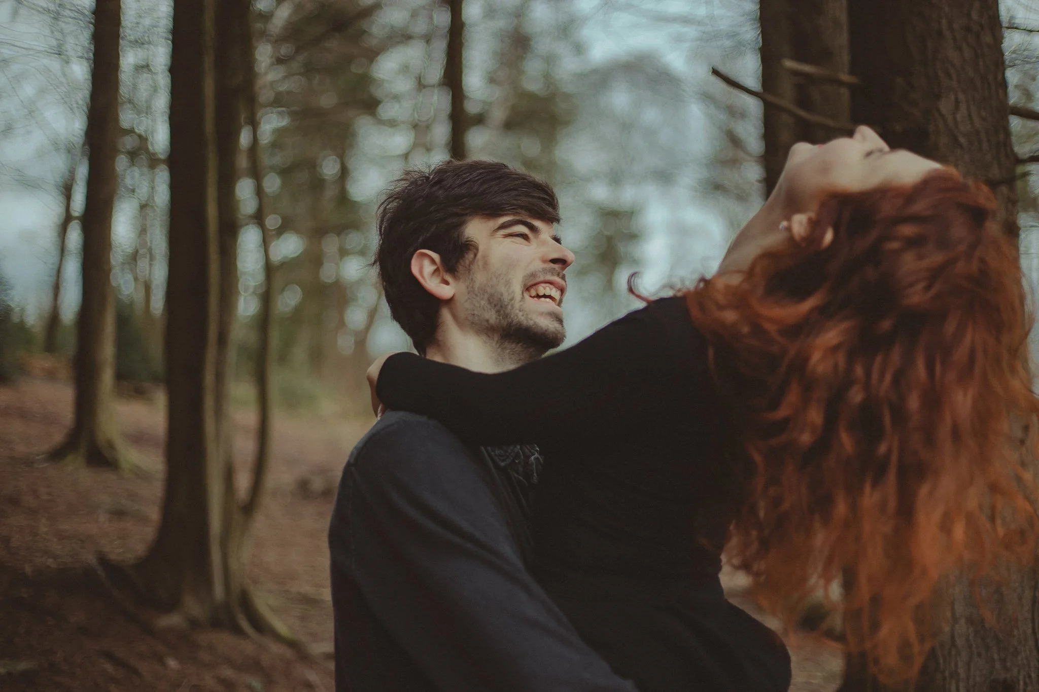 Young couple having a good time in a forest near Birmingham, during their engagement photoshoot