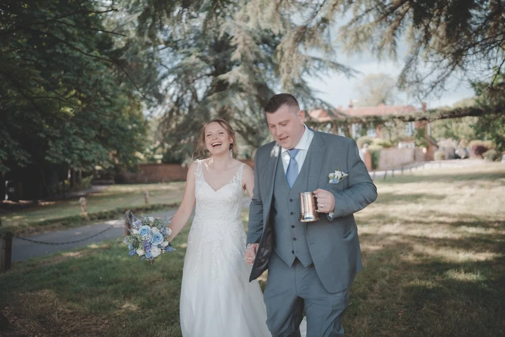 Candid photo of a young couple that just got married and are having fun at Monks Barn