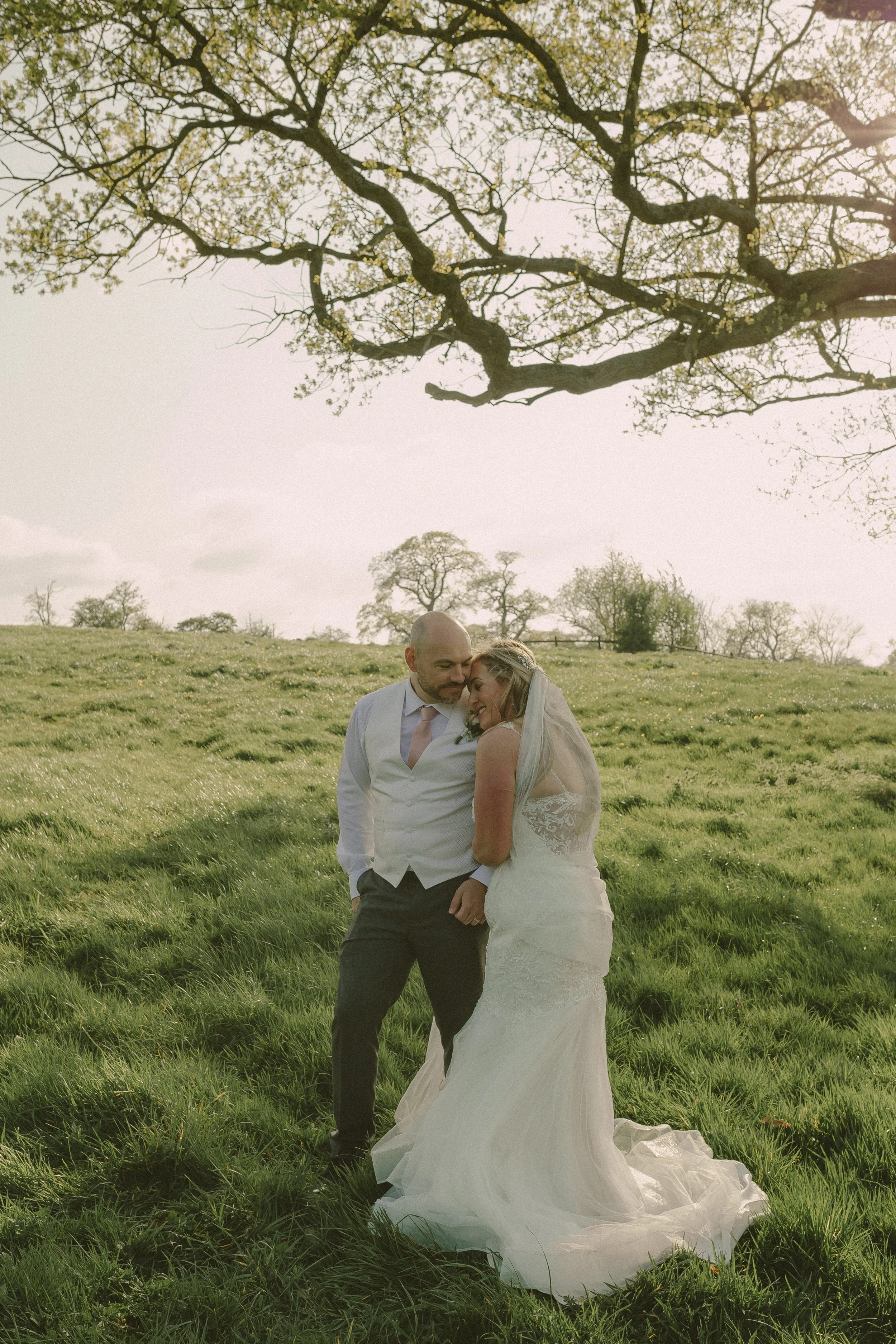 Bride and groom photographed on a field on their wedding day