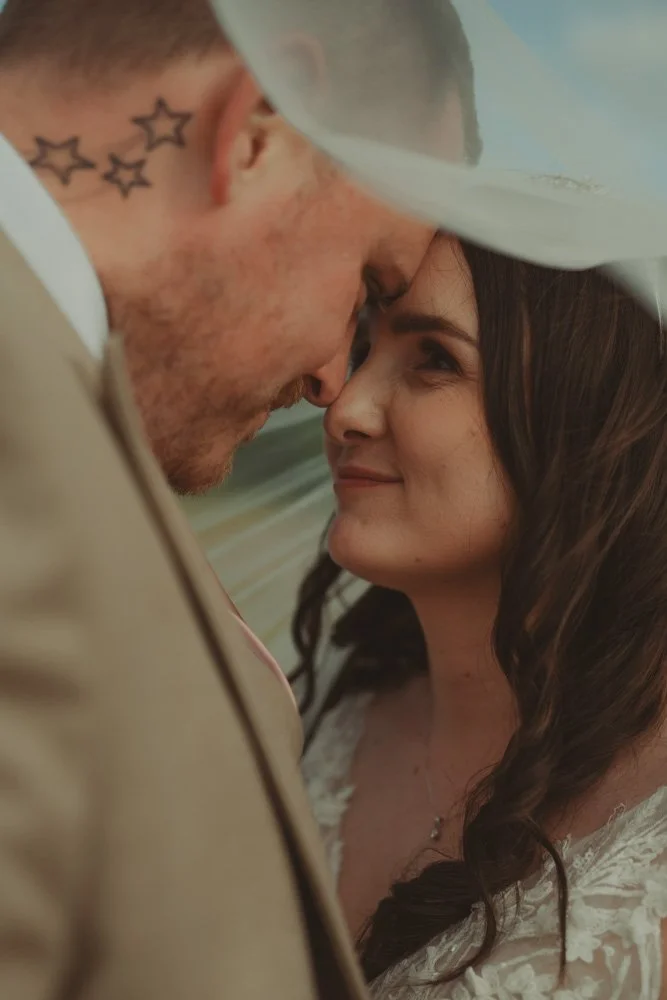 Close-up portrait of a bride and groom looking into each others eyes, at Wellington Barn, Wiltshire