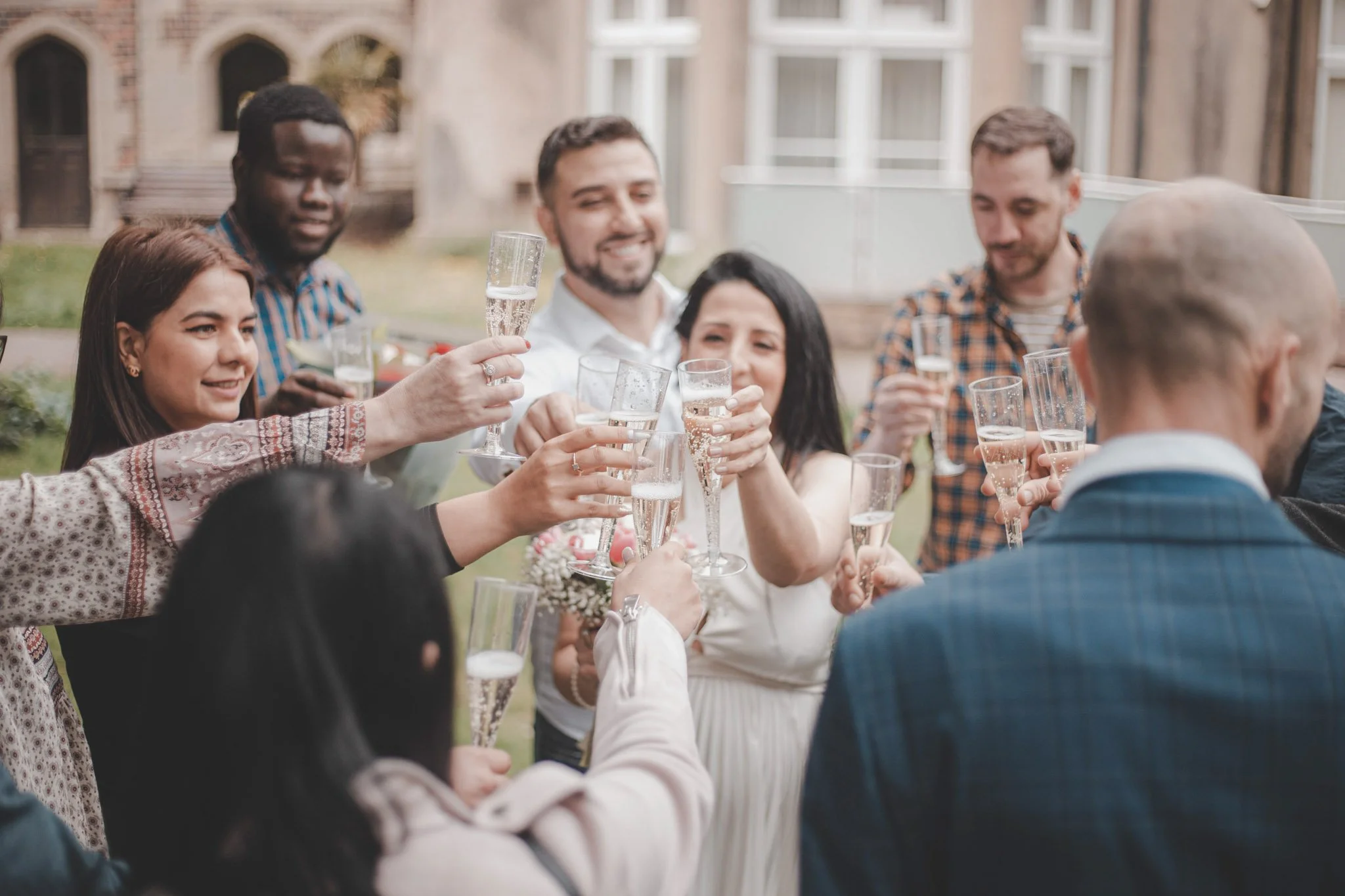 Bride and guests enjoying a glass of champaghe on her wedding day
