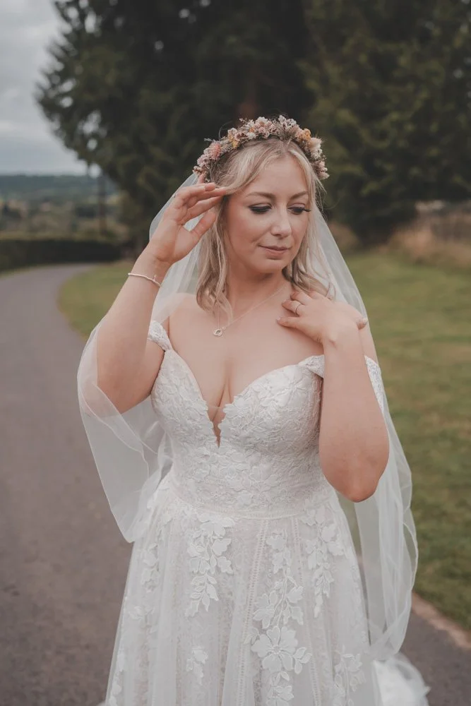 Half body portrait of a bride, on her wedding day, looking away, at The Courtyard at Shelsley Walsh
