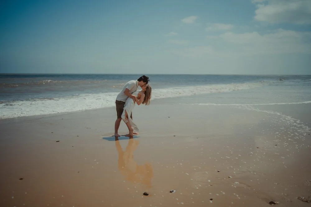 Couple kissing while doing a dip on  Covehithe Beach