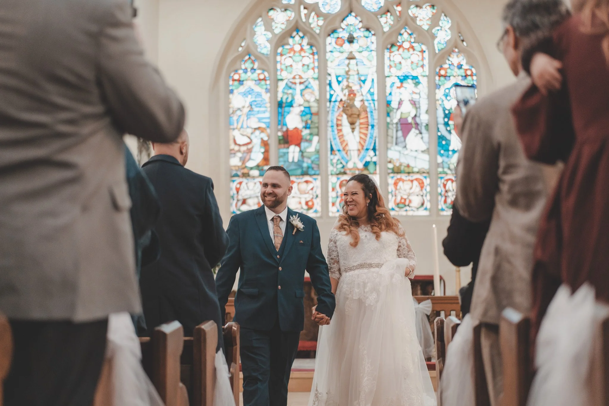 Bride and groom walking down the aisle after their religious ceremony at St Andrews Church, Whittlesey, Cambridgeshire