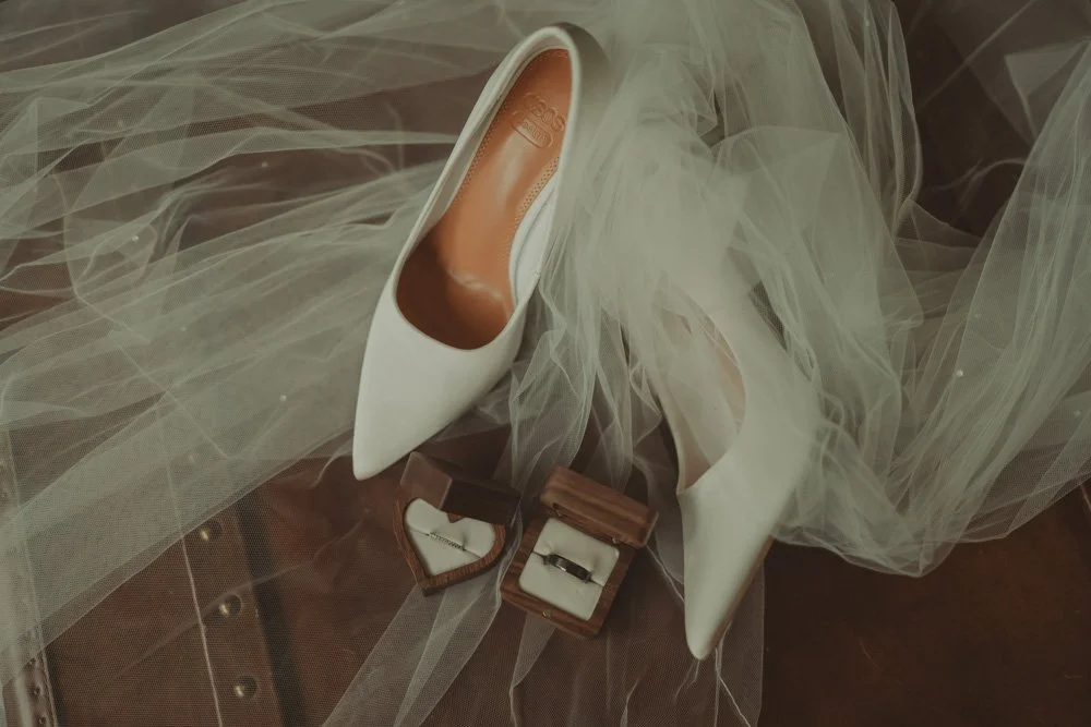 Details of wedding rings, veil and shoes, on a wooden chest at Hygge House, Wiltshire