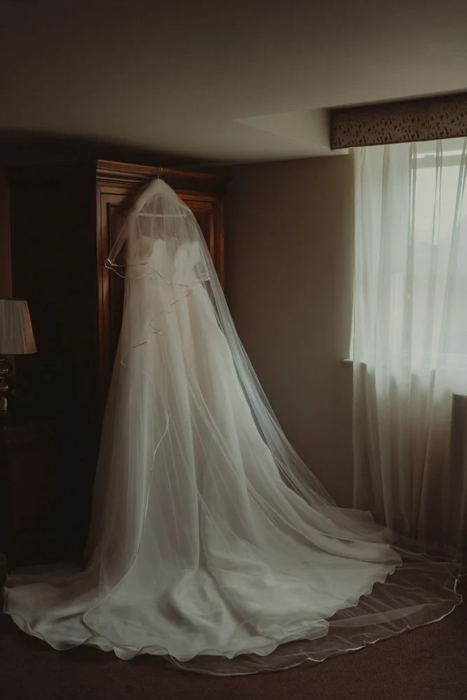 Wedding dress photographed in low light at The White Hart Inn at Lydgate