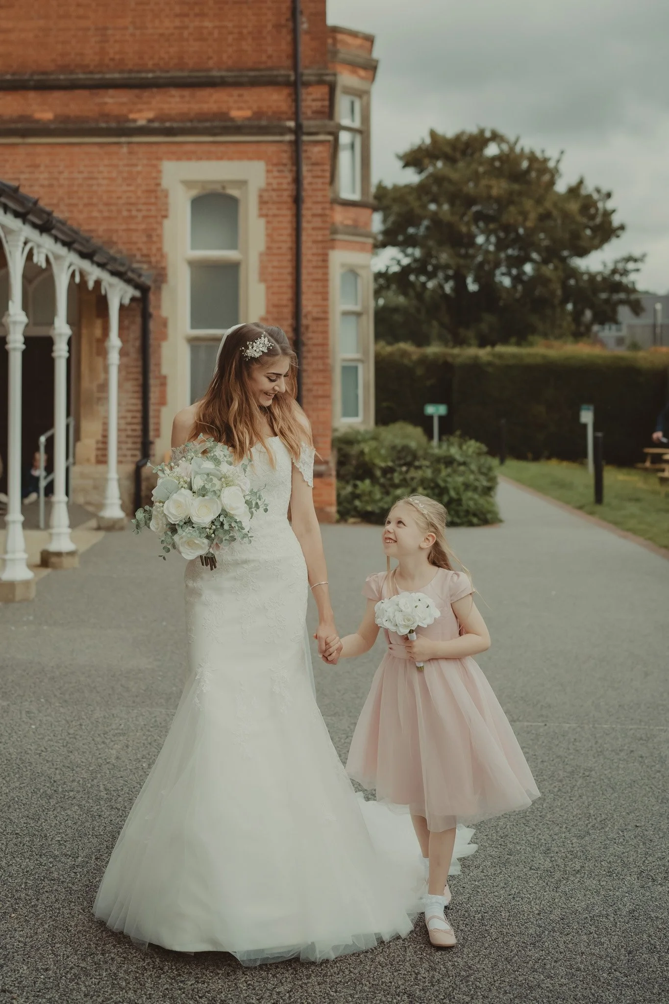 Bride holding hands with her little daughter on her wedding day at the Kent Register Office Oakwood House, Maidstone