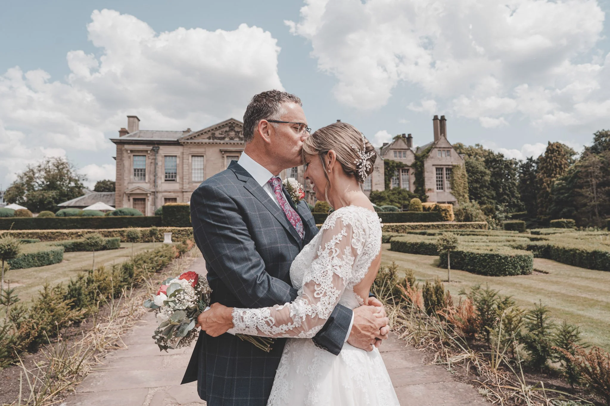 bride and groom sharing an intimate moment during their wedding day photoshoot at Coombe Abbey Hotel, Coventry