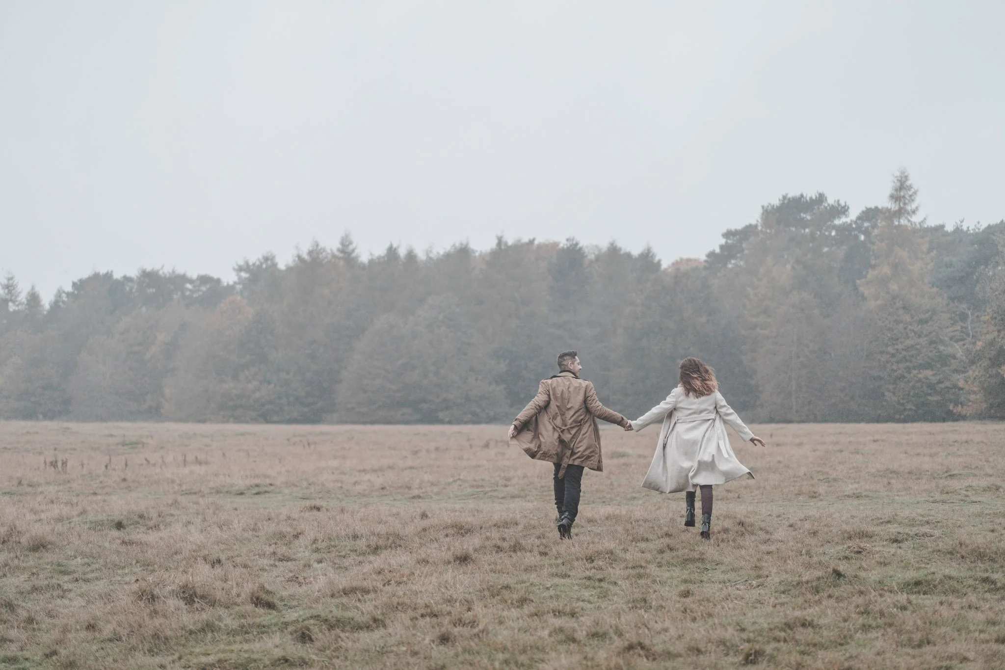 Couple running on a field in Coombe abbey, Coventry, at a save the date photoshoot