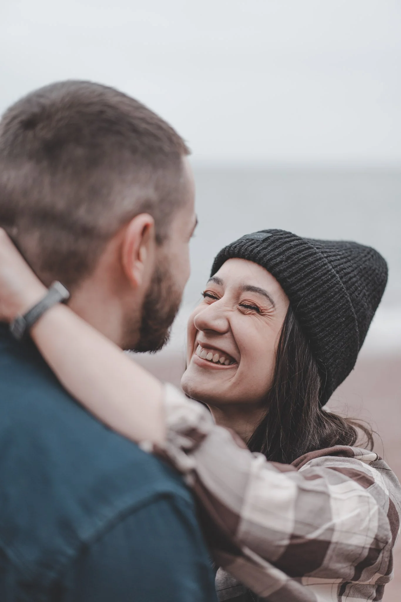 Couple having a laugh while photographed on a beach