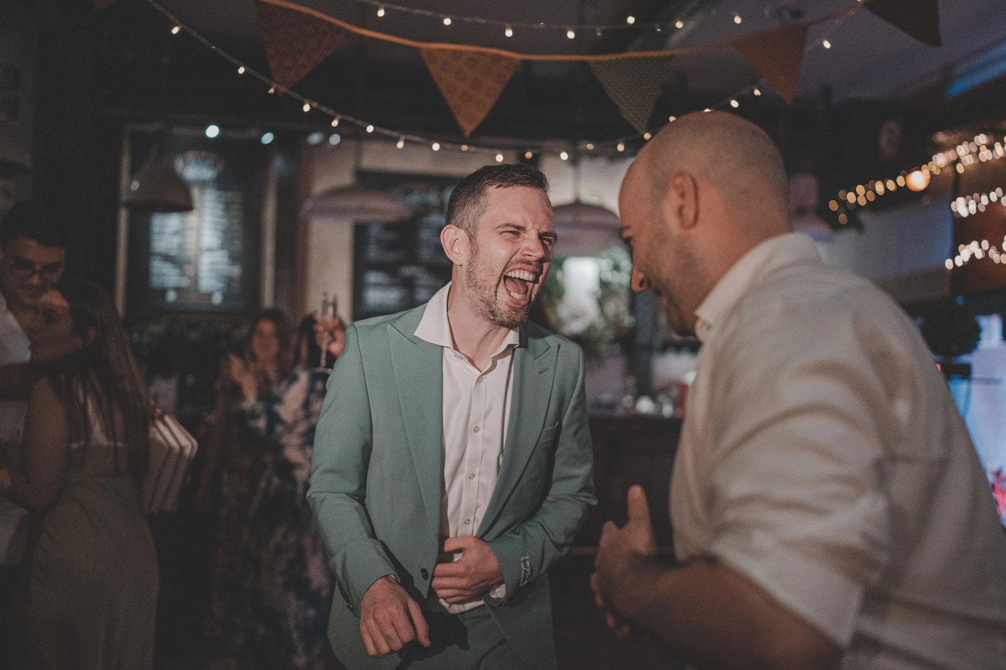 Two men having a laugh during a wedding at the Depot, London 