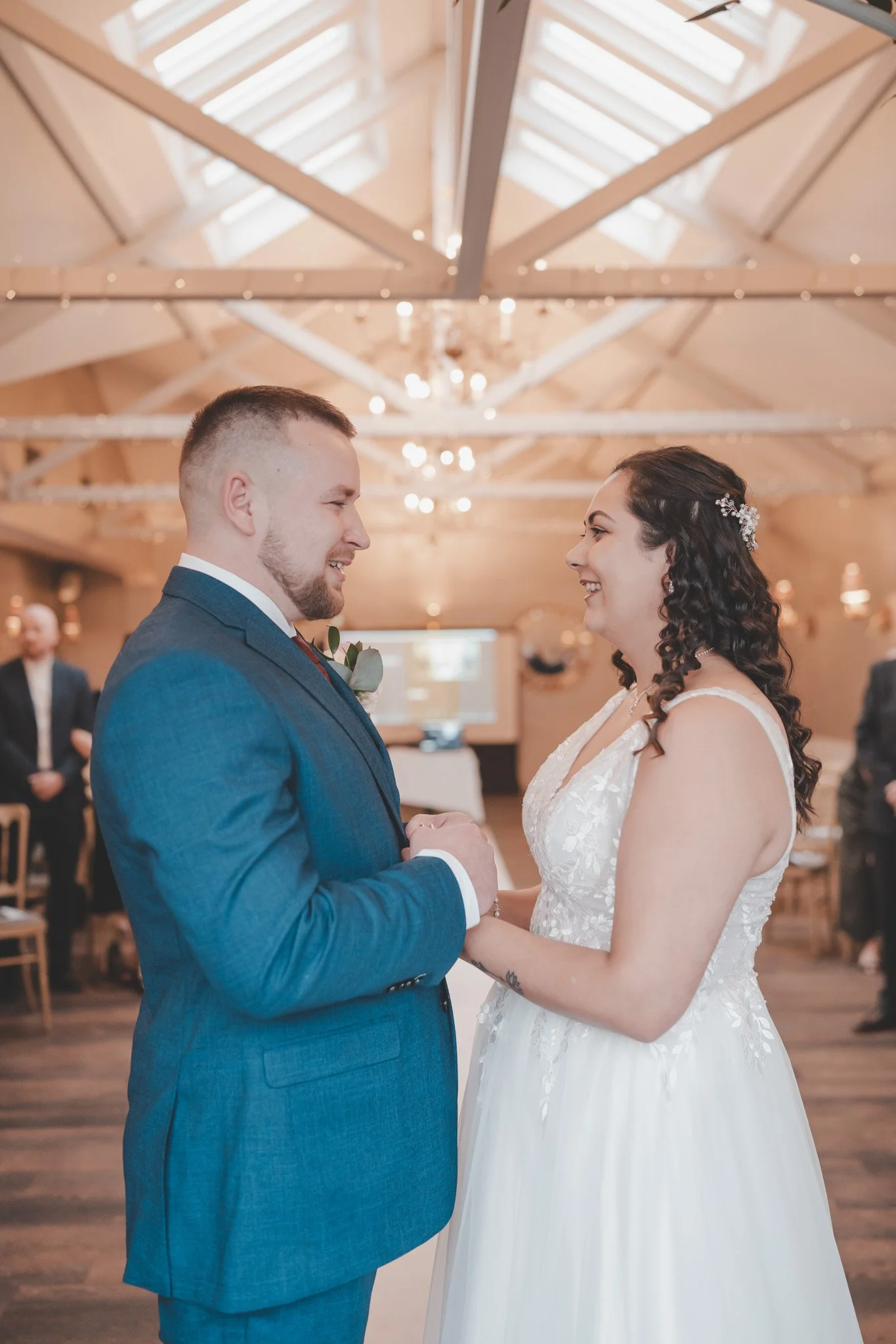 Bride and groom facing each other and holding hands during their wedding ceremony at Cockliffe Country House