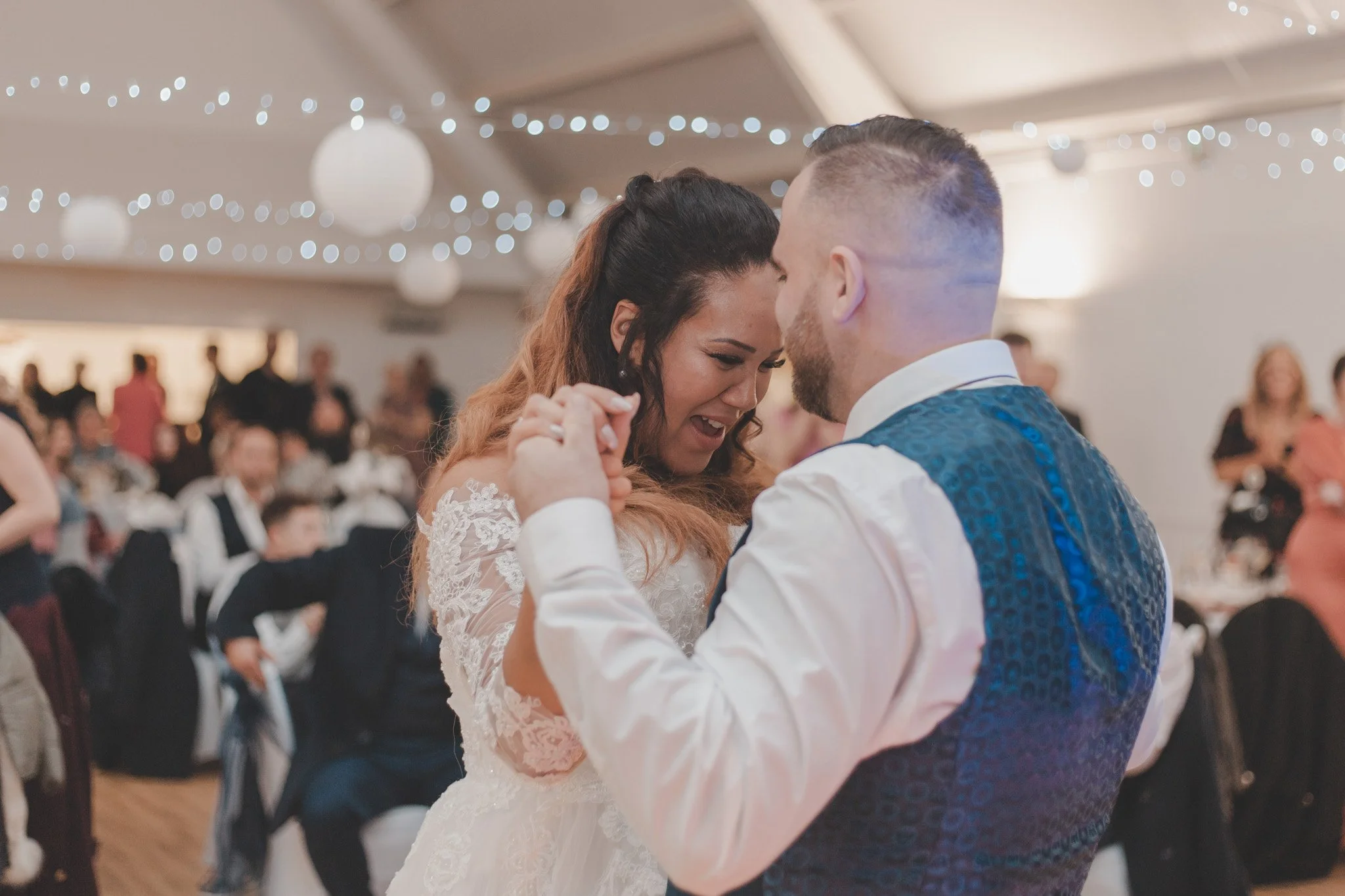 Bride and groom having a good time during their first dance, surrounded by their wedding guests at The Eastrea Centre, Cambridgeshire