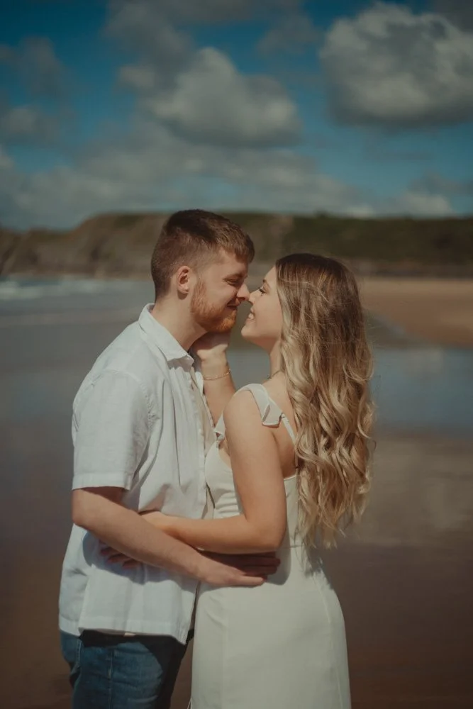 Portrait of a couple kissing on the beach of Three Cliffs Bay, Wales