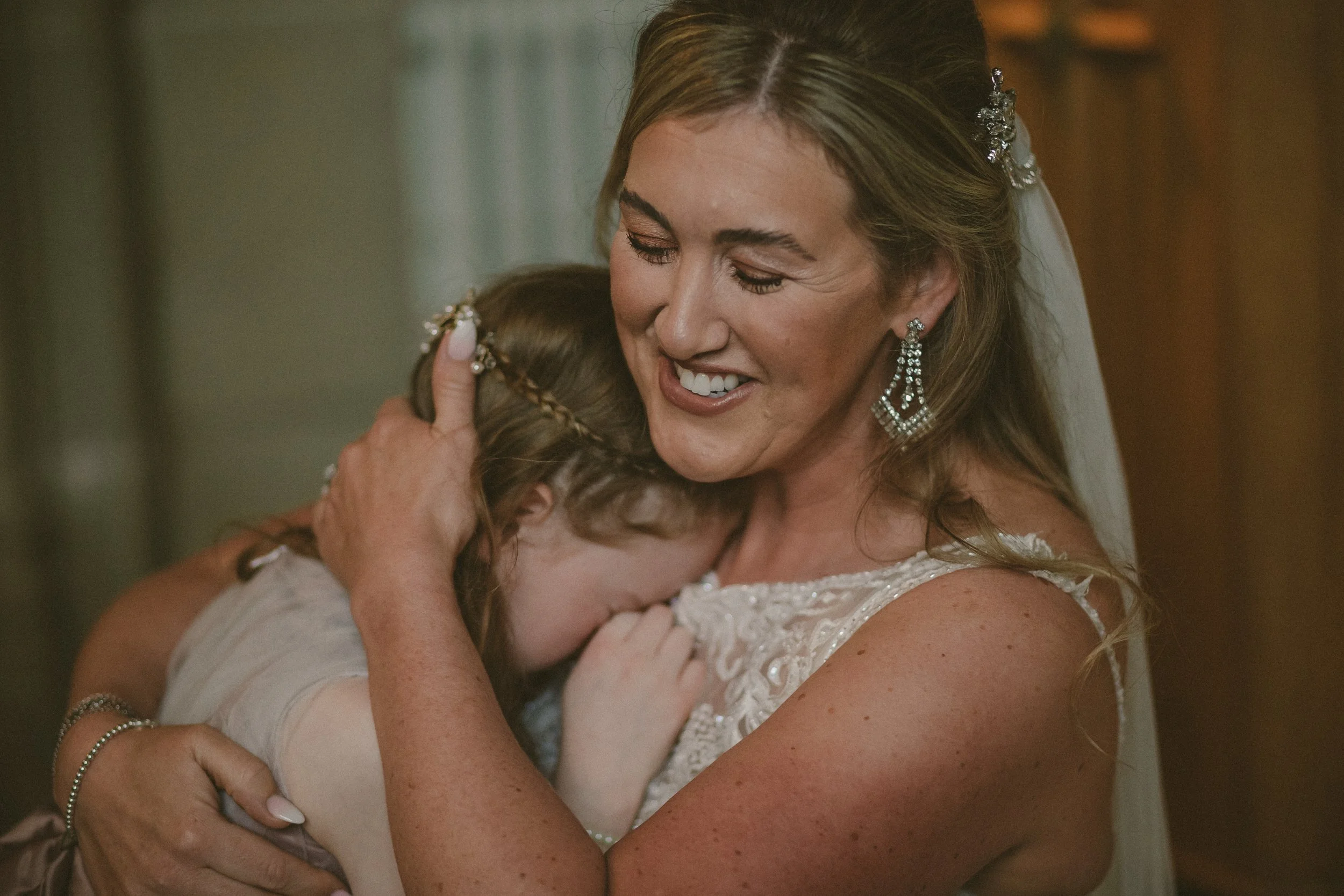 Bride hugging her emotional daughter on her wedding day