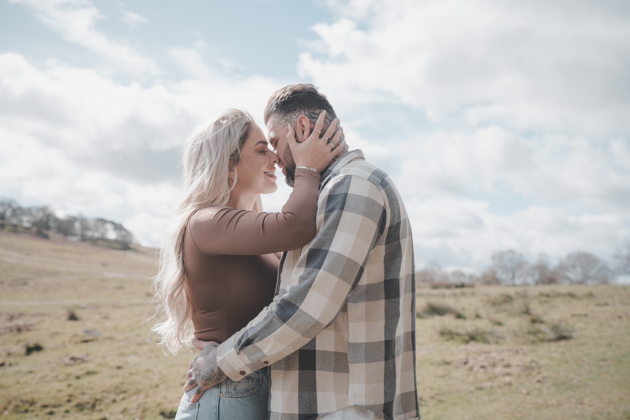 Couple holding each other and kissing during a family photo session in Bradgate Country Park in Leicester