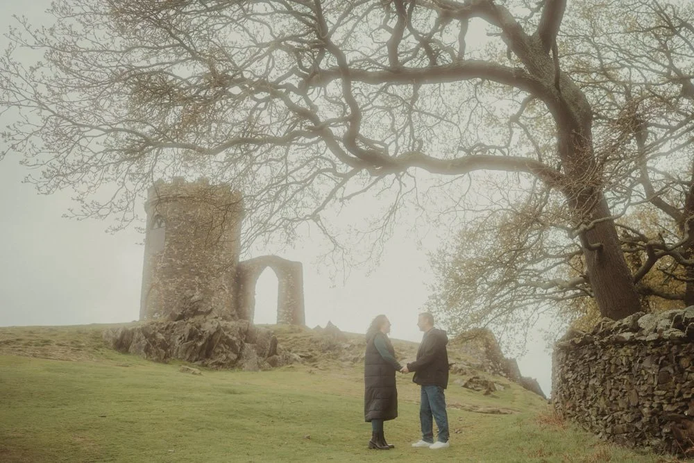 Couple holding hands in front of Old John Tower at Bradgate Deer and Country Park