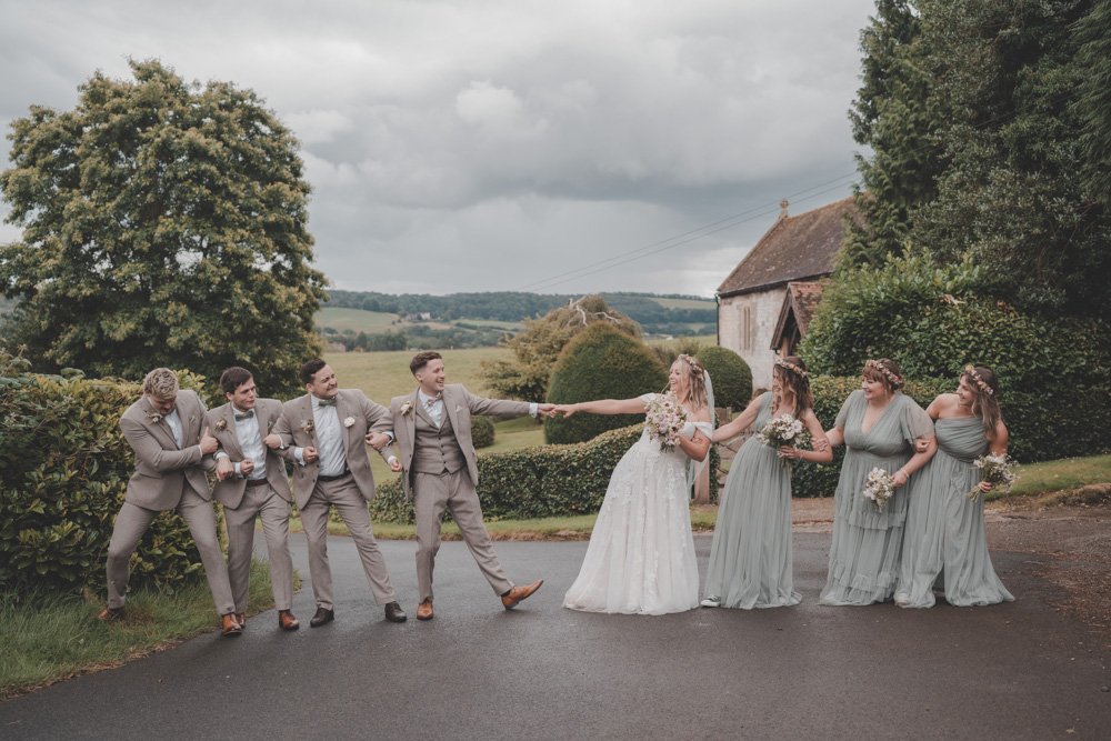 Funny photo of bride, groom, groomsmen and bridesmaids, at The Courtyard at Shelsley Walsh