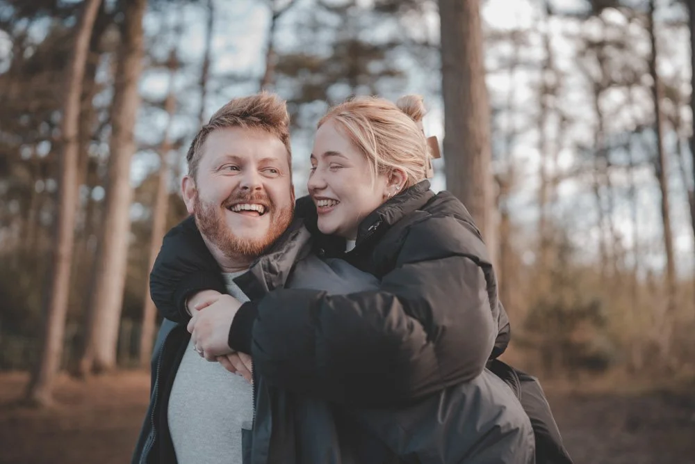 Young couple having fun together at their pre-wedding photoshoot at Cuerden Valley Park