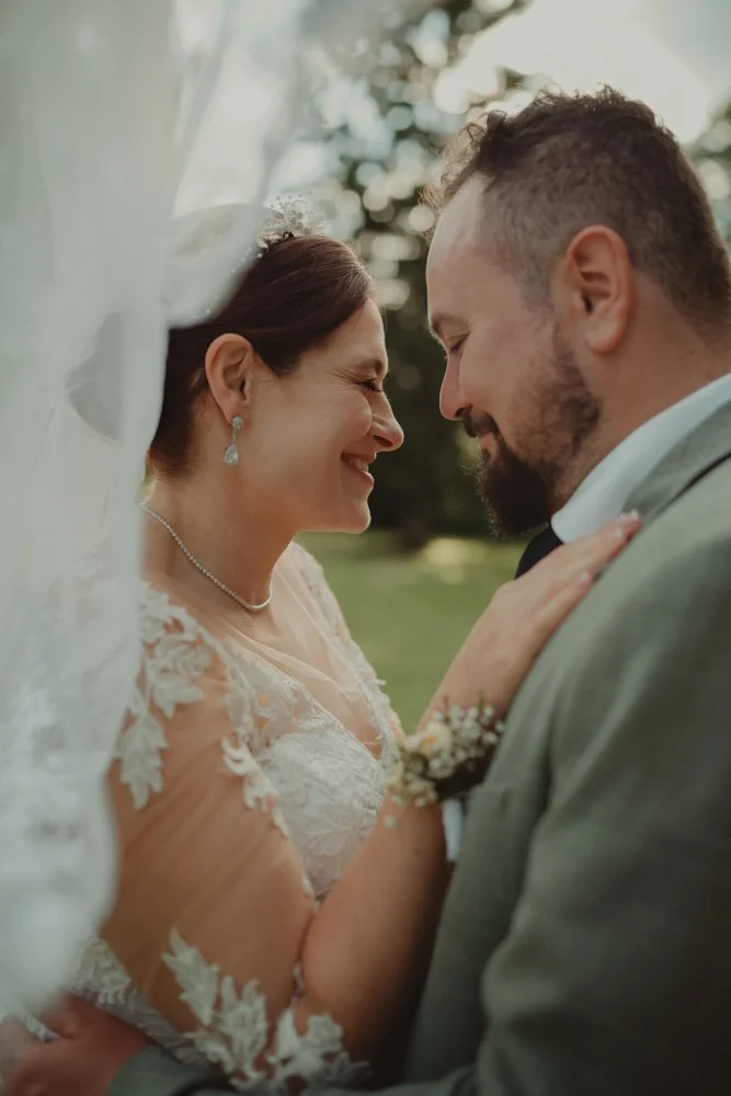 Close-up portrait of a bride and groom laughing at Brockencote Hall Hotel, Kidderminster, on their wedding day