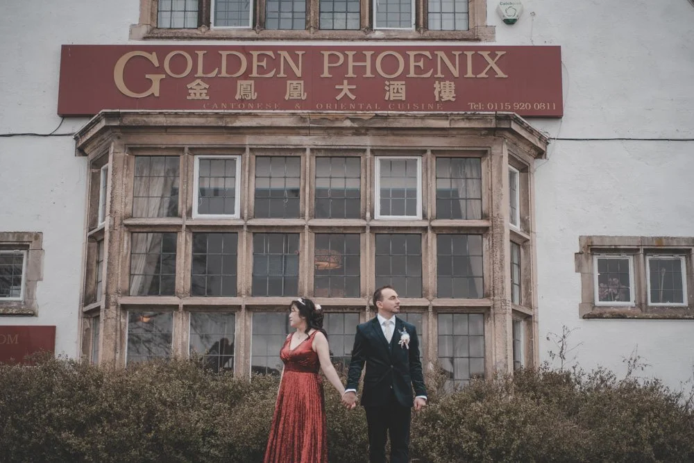 Bride and groom holding hands in front of Golden Phoenix restaurant in Nottingham