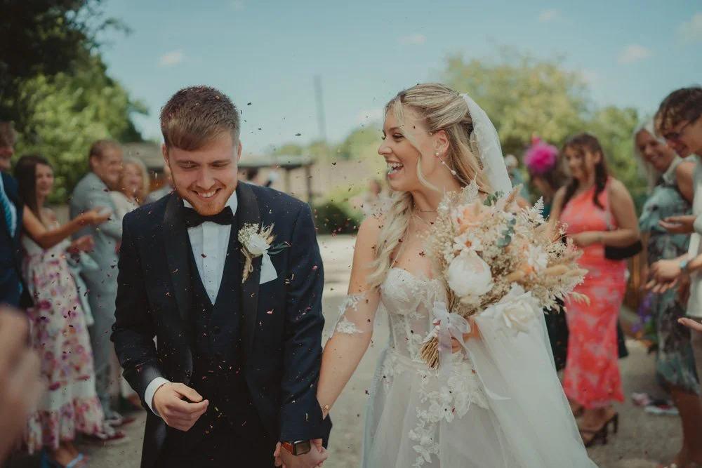 Young bride and groom during a confetti exit at Gwesty'r Emlyn Hotel in Newcastle, Wales