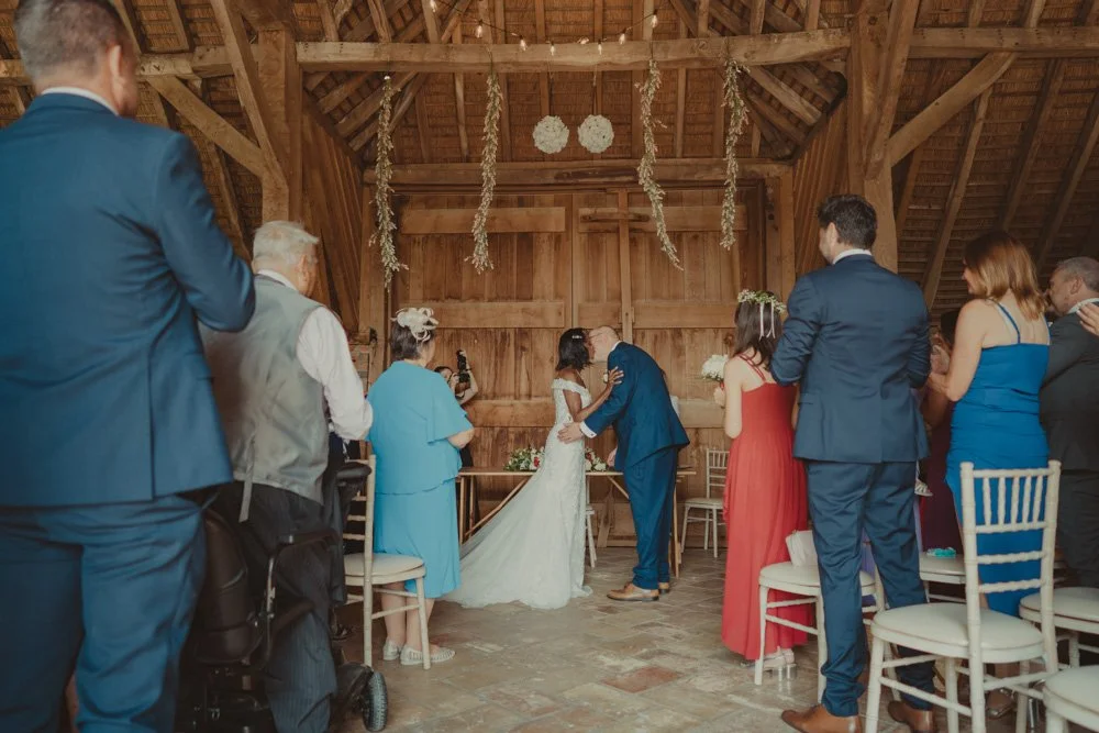 Bride and groom in front of the altar in a barn in Drayton, Oxfordshire