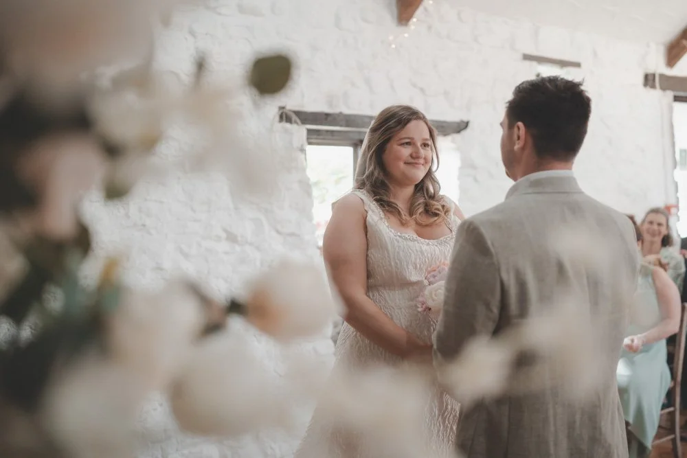 Bride and groom facing each other during their wedding ceremony, at Clyne Farm Centre