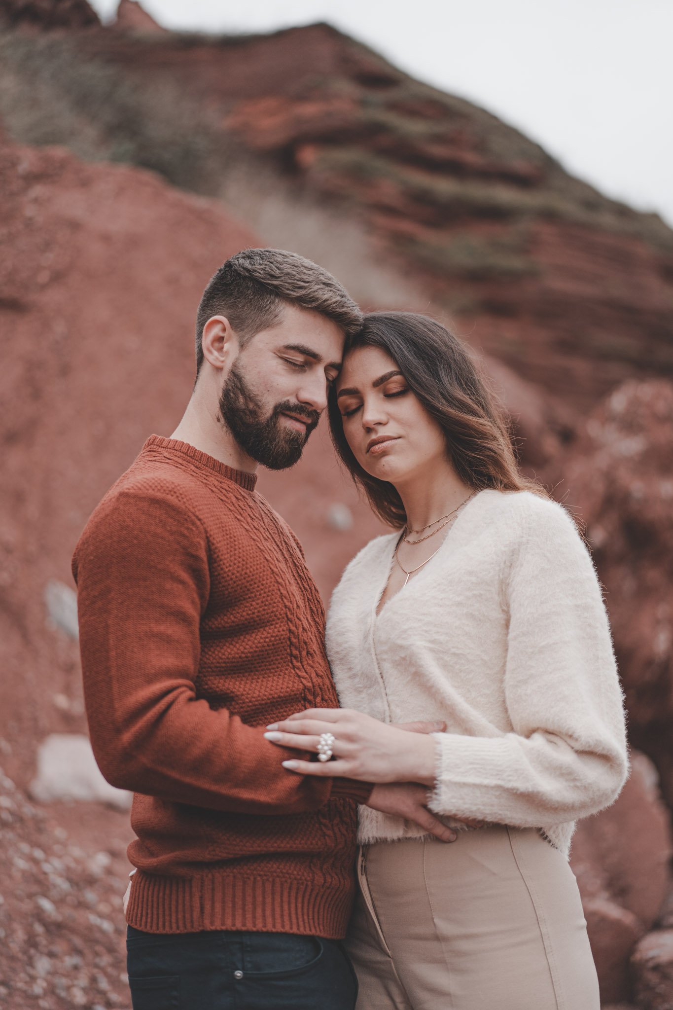 Couple posing during their couple photoshoot on a beach in Torquai