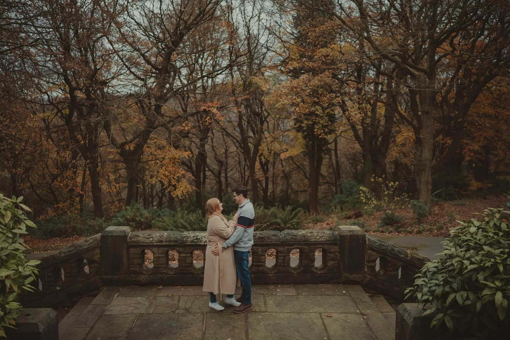 Couple holding each other during a autumn save the date photoshoot in Beaumont Park Huddersfield